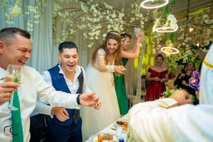 Wedding reception venue with elegant lighting and floral decor during lively celebration.