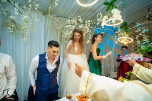 Candid moment at wedding reception with guests gathered around decorated dining table.