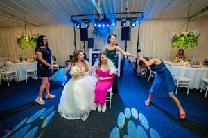 Indoor wedding reception with energetic dancing and atmospheric blue lighting effects.