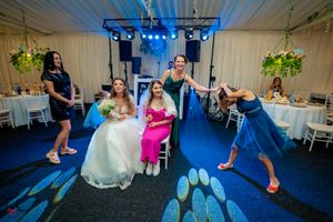 Wedding guests enjoying dance floor moments under dramatic blue venue lighting.