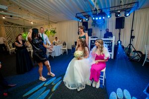 Reception venue with dramatic blue lighting and guests celebrating on the dance floor.