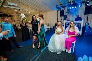 Wedding venue with blue uplighting and guests dancing in a tent-style reception space.