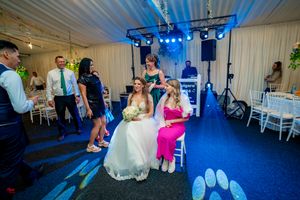 Wedding reception dance floor with blue lighting and guests enjoying the celebration.