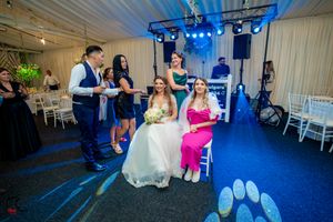 Wedding venue decorated with blue lighting as guests celebrate on the dance floor.