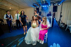 Wedding reception hall with stage lighting and guests enjoying the celebration.