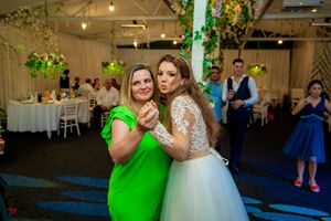 Wedding celebration in a decorated venue with blue and green lighting accents.