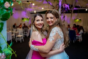 Joyful celebration moment at wedding reception with pink and white decor details.