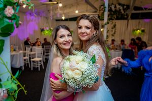 Wedding celebration moment with beautiful white bouquet in decorated reception venue.