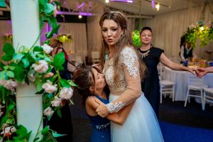 Wedding celebration with guests sharing emotional moments under decorative lighting.
