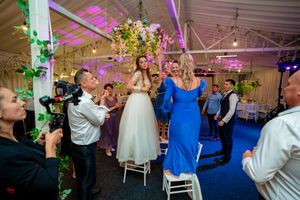 Reception venue with elegant white chairs and romantic purple uplighting for evening celebration.