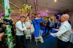 Wedding guests enjoying festivities on dance floor with atmospheric lighting and decor.