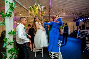 Festive dance floor with blue and purple lighting at an indoor wedding reception.
