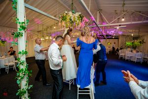 Wedding venue with blue carpet and hanging greenery showing guests enjoying the celebration.