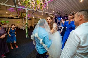 Wedding celebration showing guests dancing in an elegantly decorated indoor venue with mood lighting.