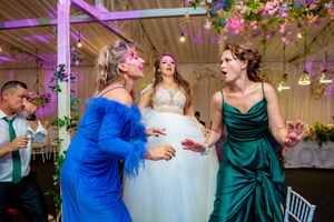 Wedding reception featuring decorative floral installations and dramatic purple uplighting effects.