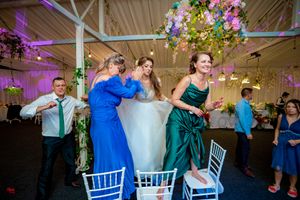 Wedding reception venue decorated with suspended flowers and atmospheric purple lighting effects.