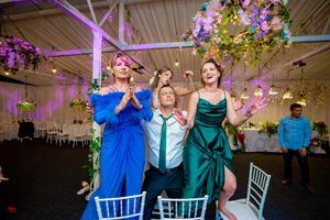 Wedding party members dancing and celebrating in coordinated formal attire.