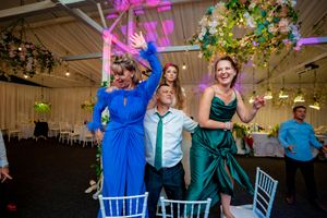 Wedding celebration with guests in coordinated blue and emerald formal wear.