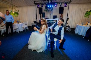 Elegant wedding venue setup with professional lighting and white draped walls.