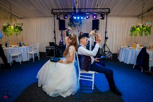 Indoor wedding reception space with theatrical lighting and elegant white drapery.