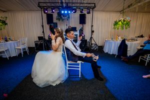 Reception hall with professional stage lighting and elegant white ceiling draping.