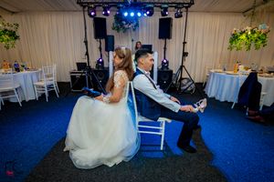 Wedding reception space with theatrical lighting system and white tent-style interior.