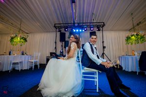 Elegant wedding venue interior with blue mood lighting and white fabric ceiling treatments.