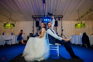 Wedding reception setup with professional lighting rig and white draped ceiling.