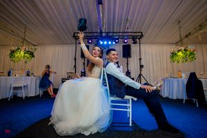 Indoor wedding venue with dramatic lighting setup and white tent-style ceiling draping.