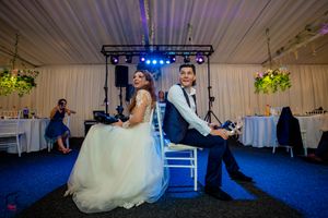 Wedding reception dance floor moments captured in a decorated indoor venue with blue lighting.