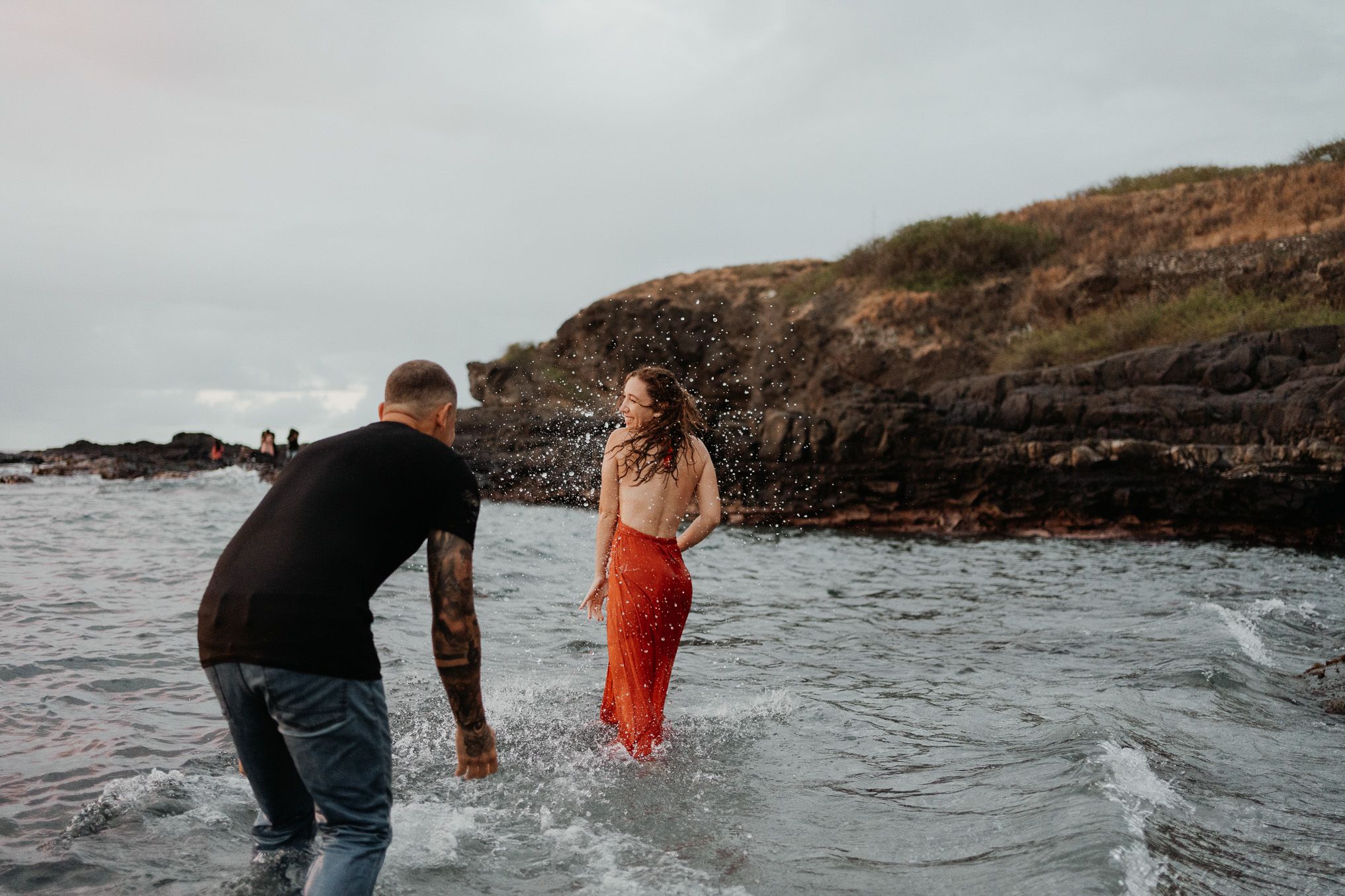 Un jeune couple joue dans la mer aux sables d'olonne