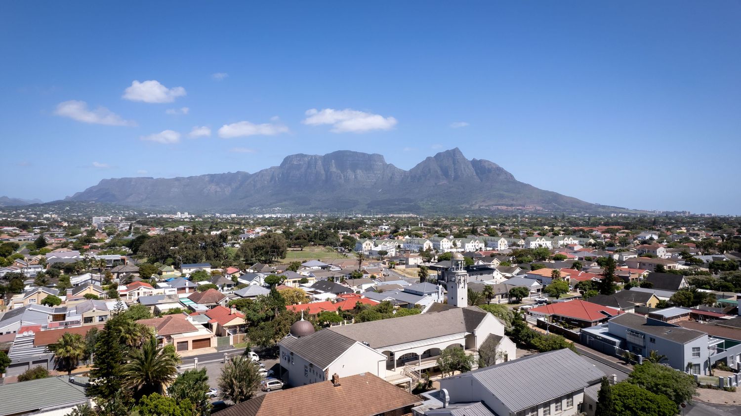 Aerial view of Cape Town suburbs with Table Mountain rising majestically in the background.