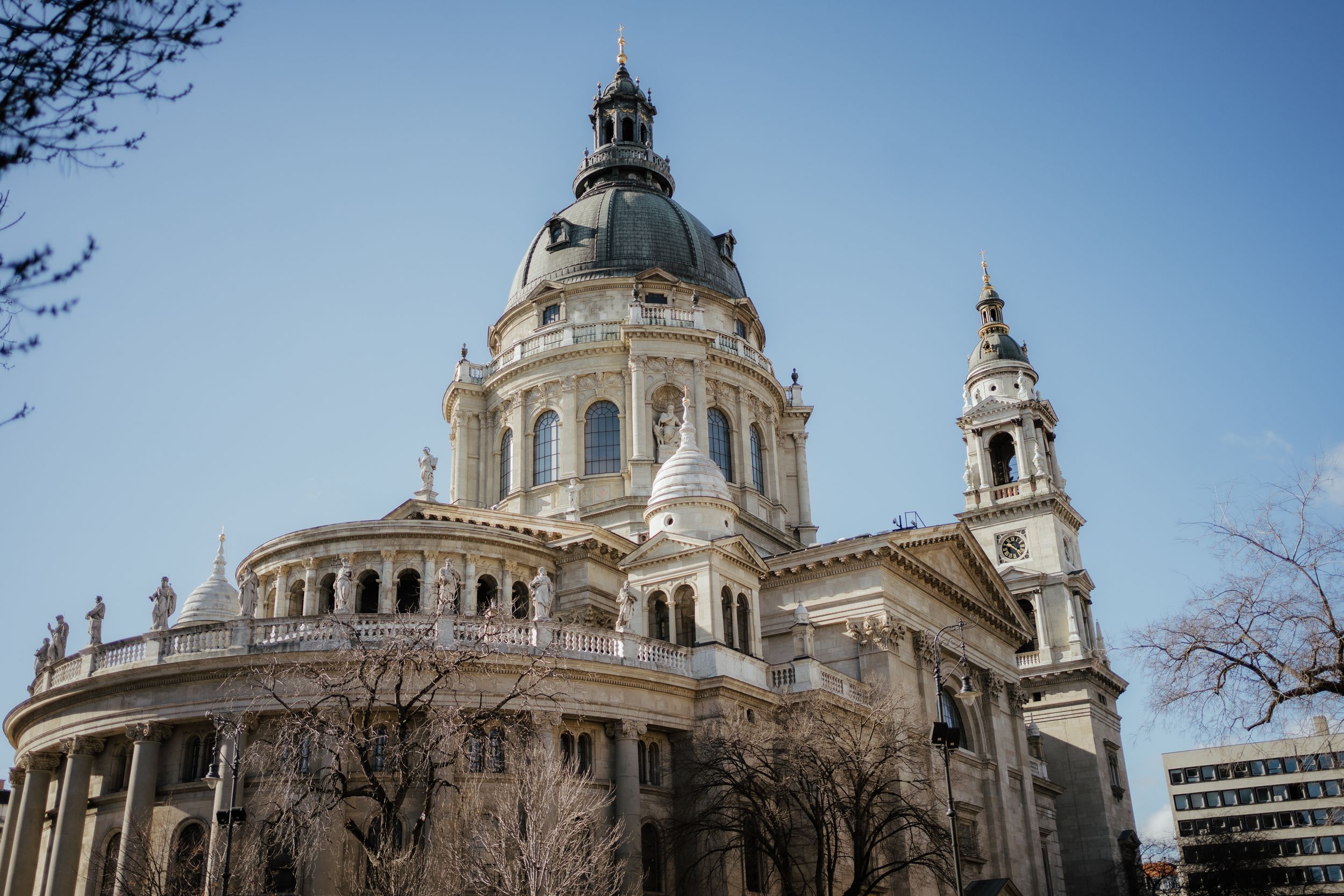 Ornate neo-baroque St. Stephen's Basilica in Budapest features grand domed architecture against cloudy winter sky.