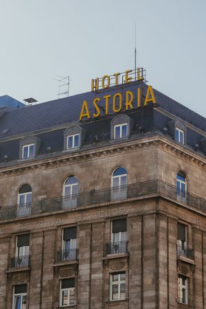 Historic Hotel Astoria building exterior with yellow rooftop signage and classic architectural details in urban setting.