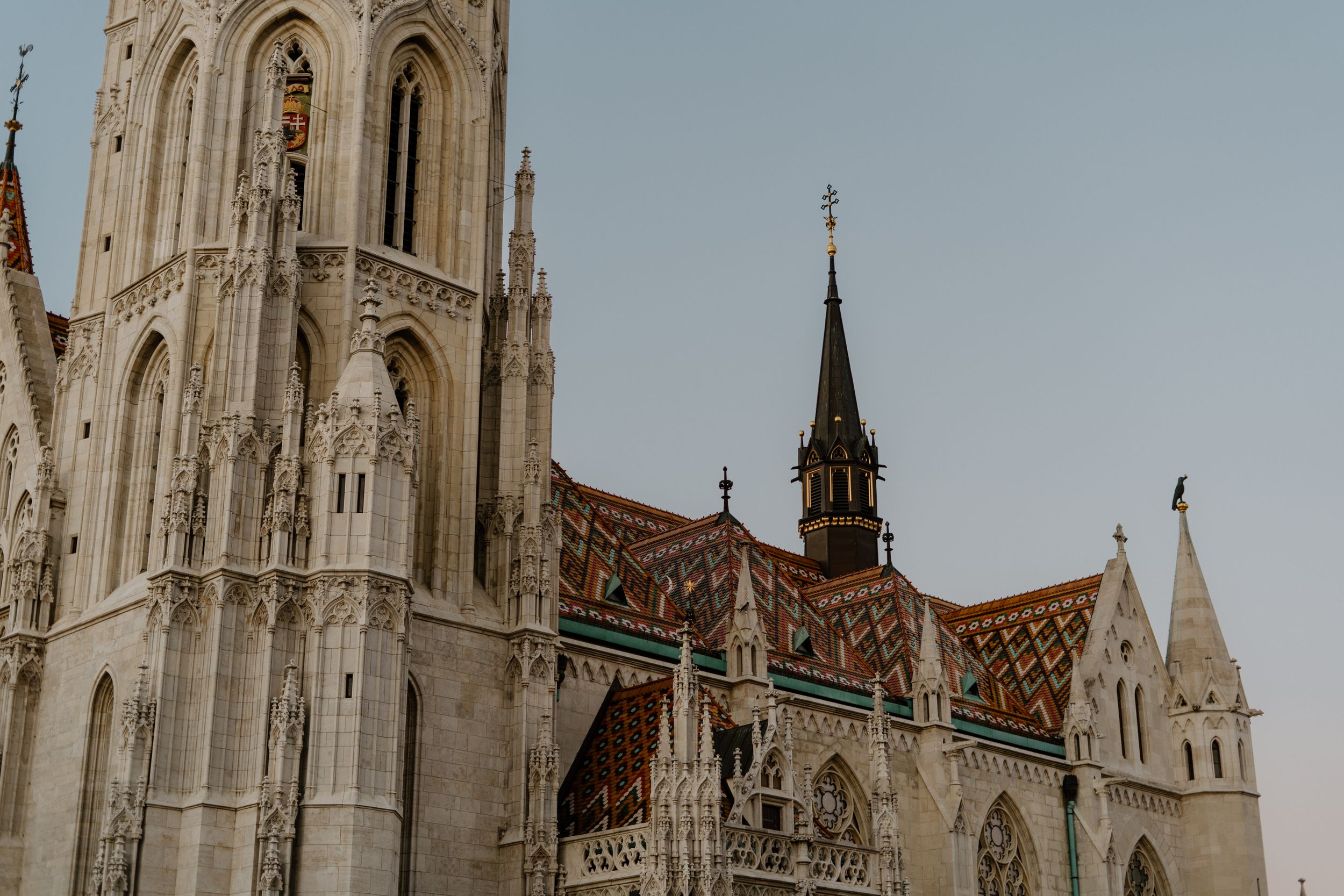 Gothic spires and ornate architecture of Matthias Church in Budapest with its distinctive tiled roof pattern and bell tower.