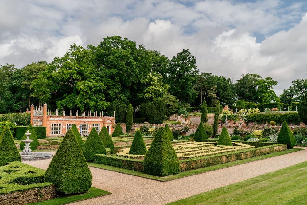 Formal garden at Oxnead Hall with perfectly manicured topiary hedges and geometric patterns at a historic estate.