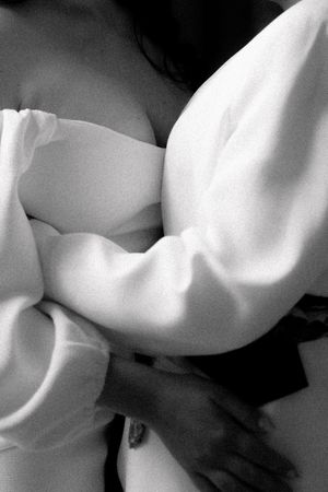 Black and white close-up of two people embracing in a tender wedding hug.