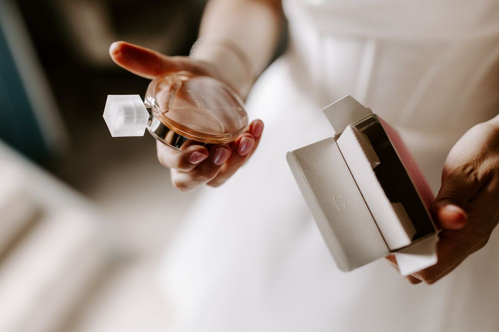 Closeup of hands holding jewelry boxes and rings in soft natural light.