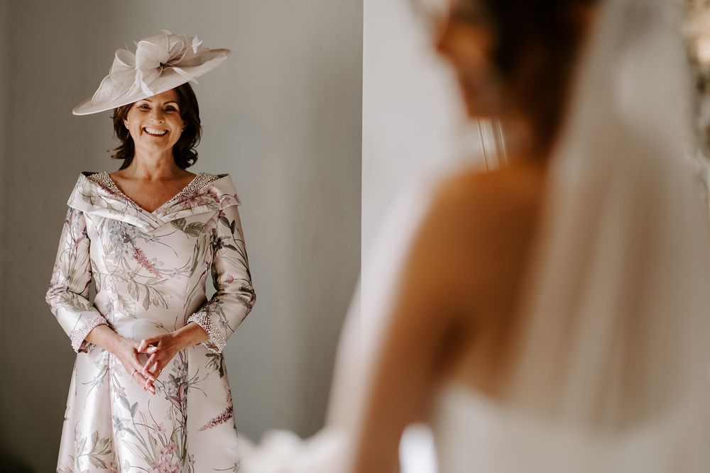 Wedding attire details showing floral patterns and elegant dresses in a light-filled room.