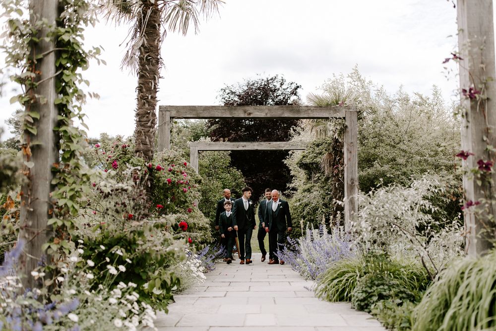 A romantic garden wedding ceremony setup with white flowers and palm trees creating an elegant outdoor atmosphere.
