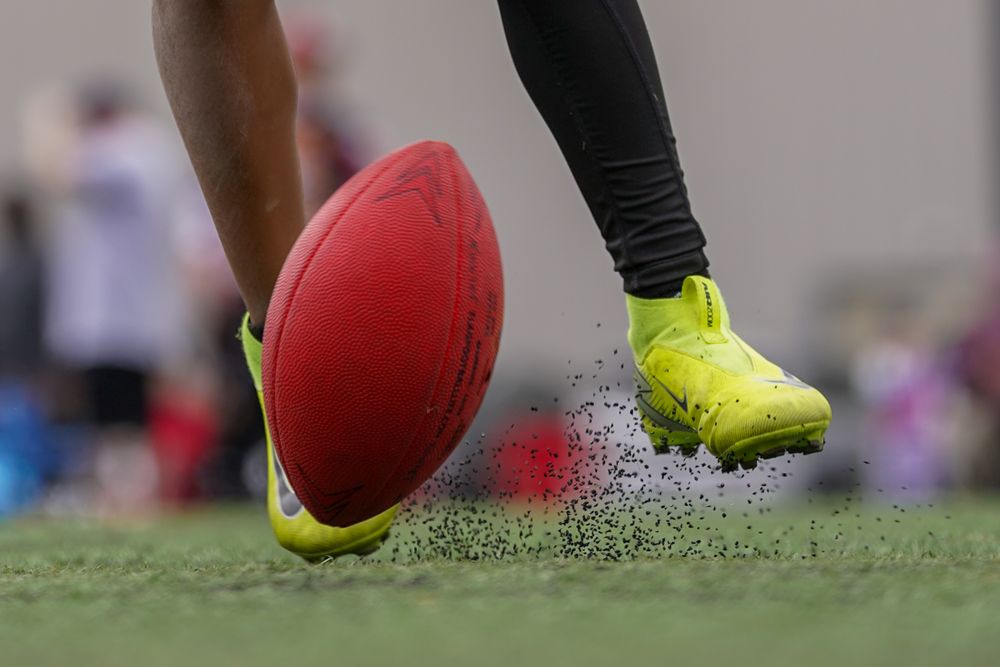 Close-up shots of rugby ball being kicked on grass field showing boot contact and ball movement in sequence.