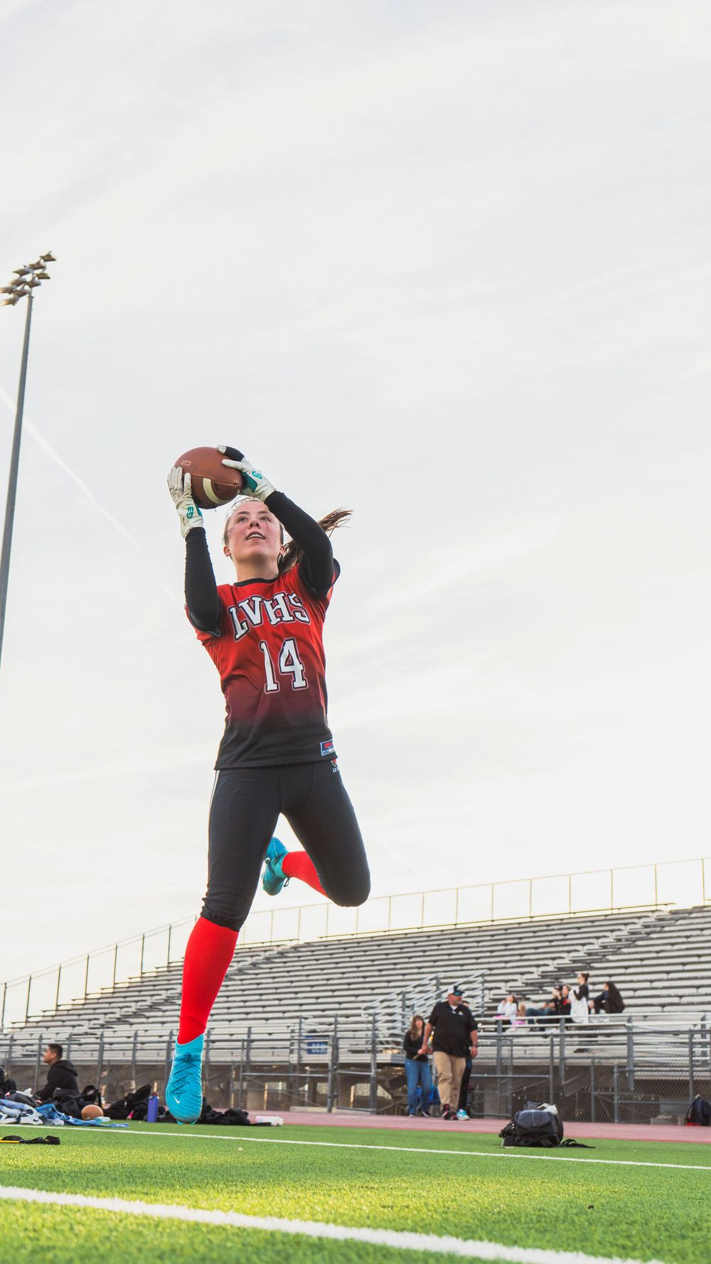 Girls flag football player making a jump catch