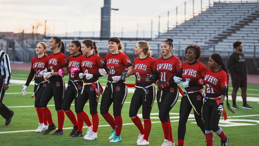 Girls flag football players arms linked as a team