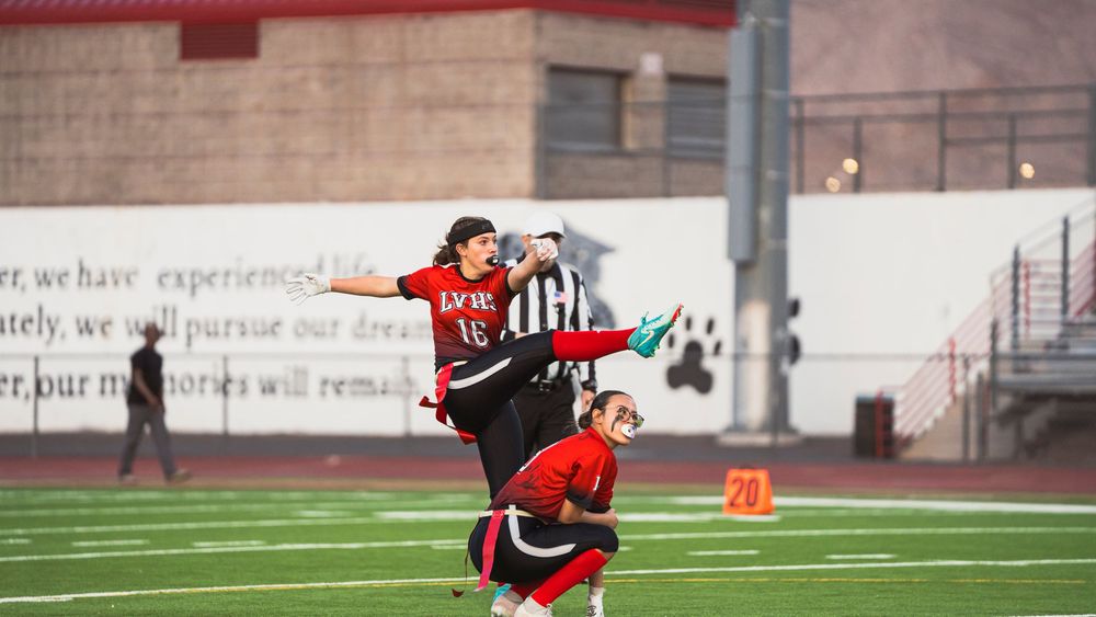 Girls flag football player kicking the football