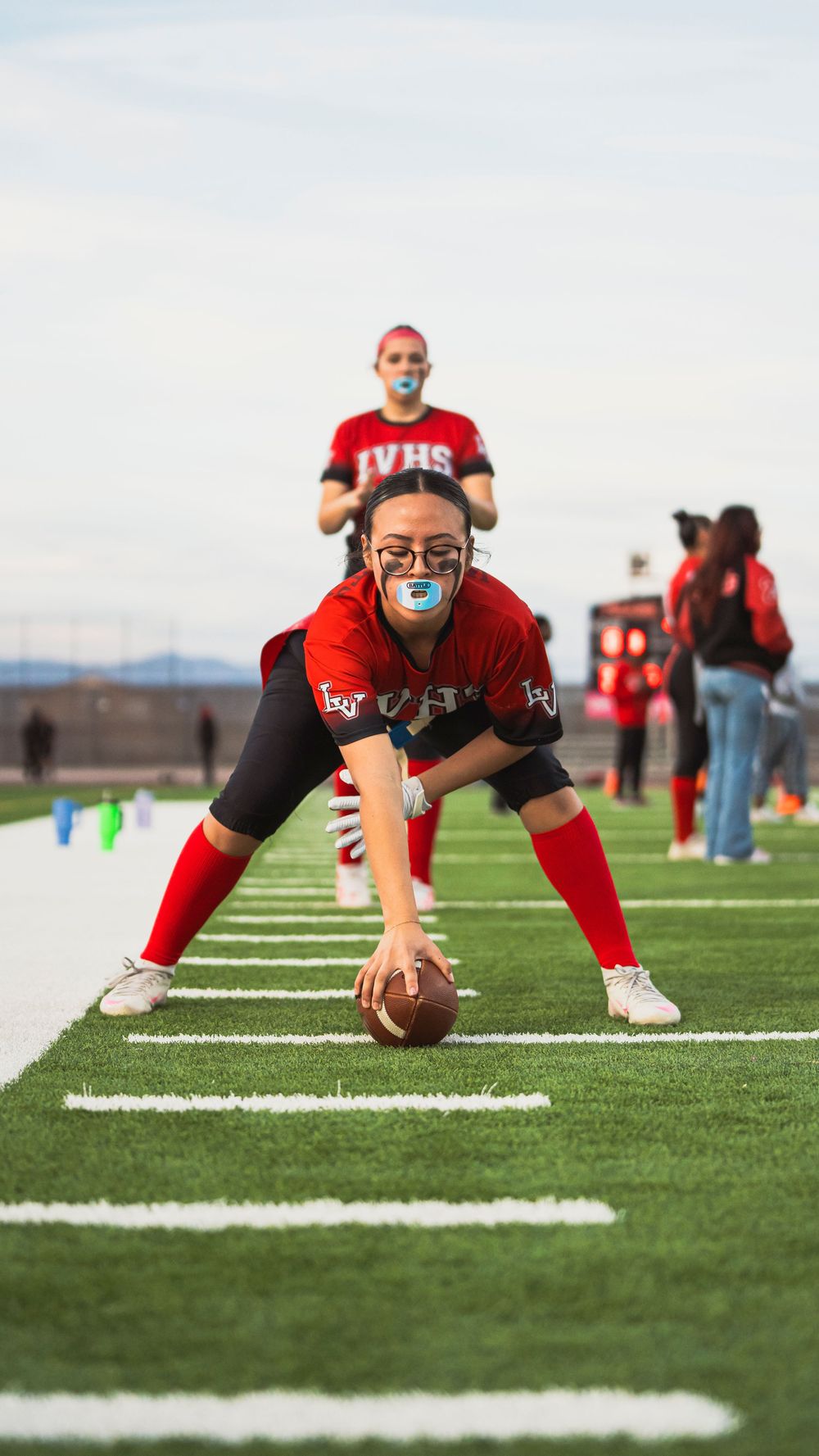 Girls flag football player hiking the football