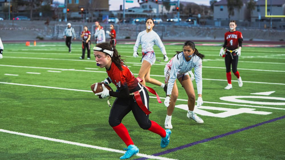 Girls flag football player running past camera