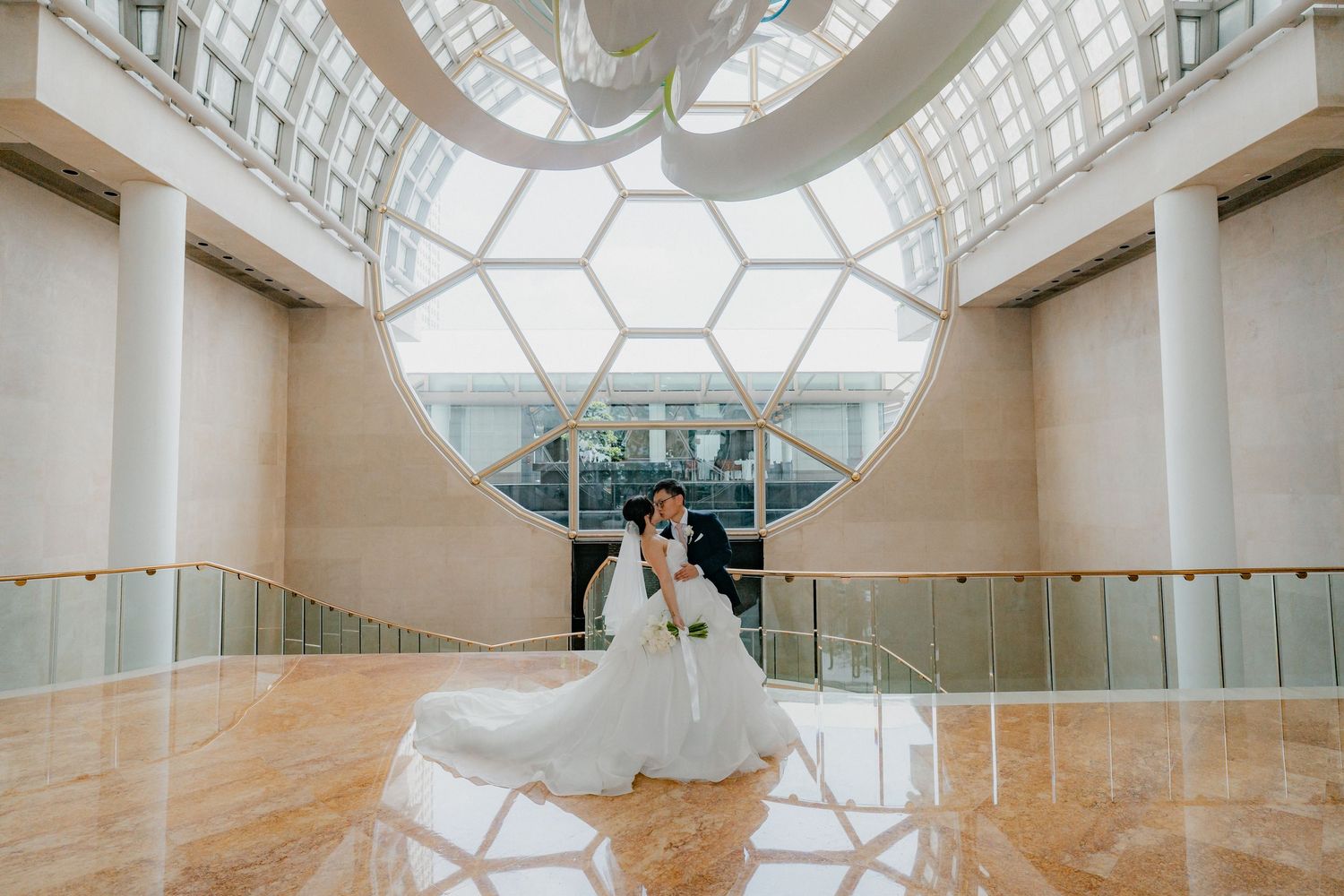Modern wedding venue interior with hexagonal skylight pattern illuminating a spacious white hall.