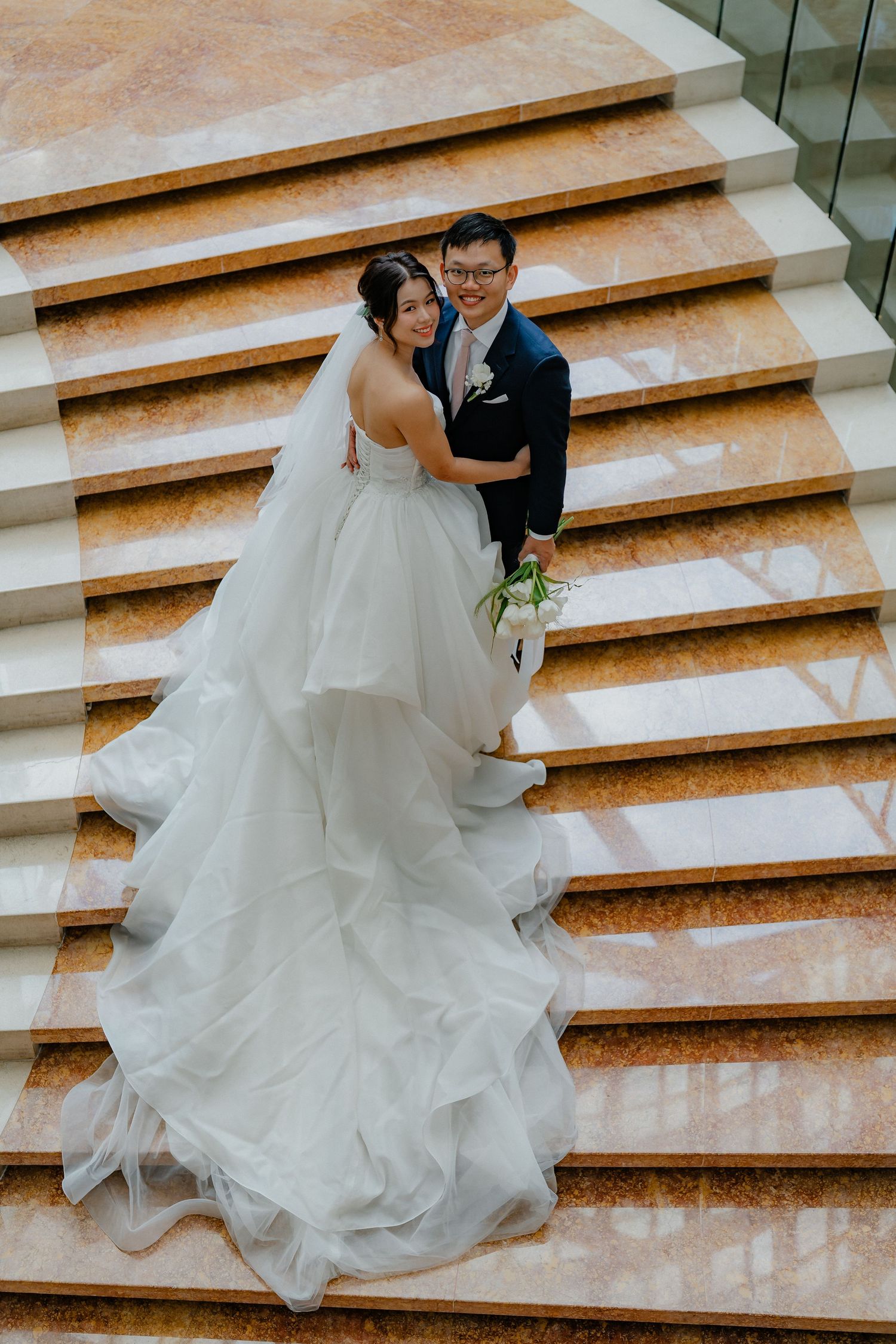 Wedding couple creates romantic moments on grand marble staircase.