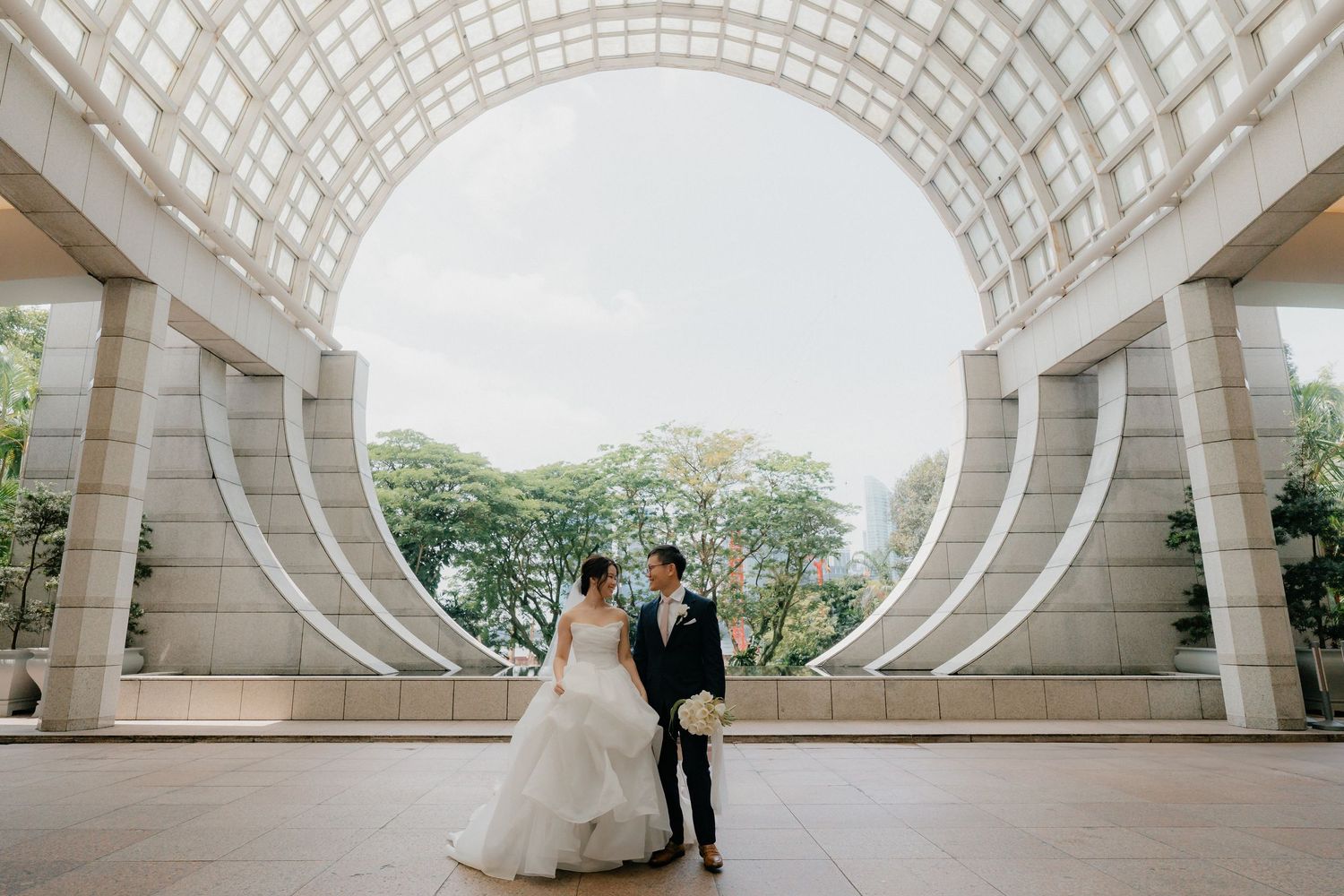 Modern architectural wedding venue features stunning white curved beams and natural lighting.