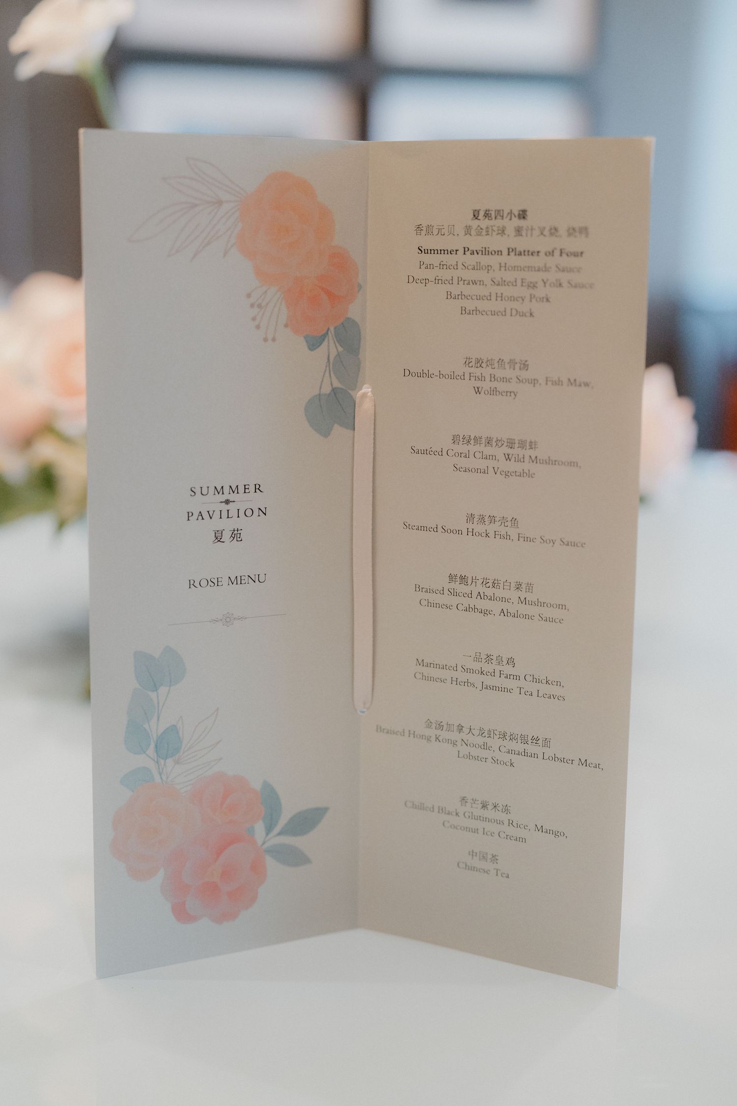 Wedding menu cards decorated with delicate pink and blue rose watercolor designs.
